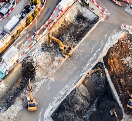 Aerial view excavators and tipper trucks working at construction. Hong Kong